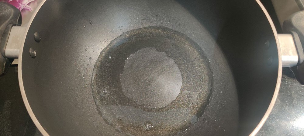warped cookware- oil pools at the sides of a warped nonstick kadai